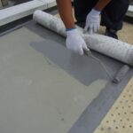 屋上の防水層を補修している業者