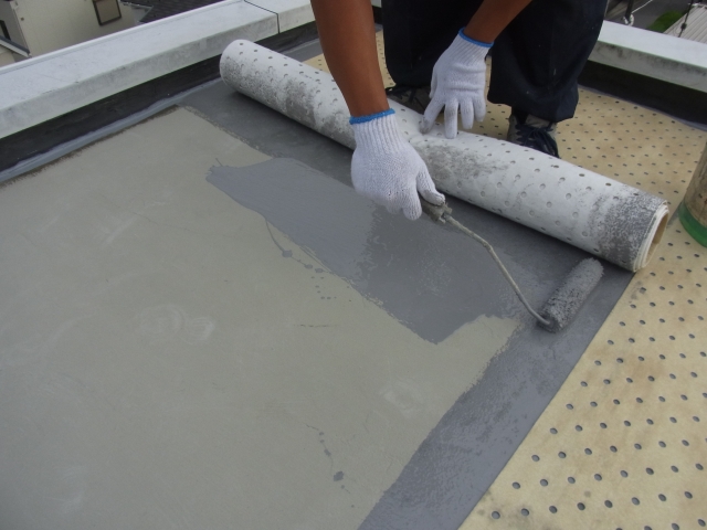屋上の防水層を補修している業者